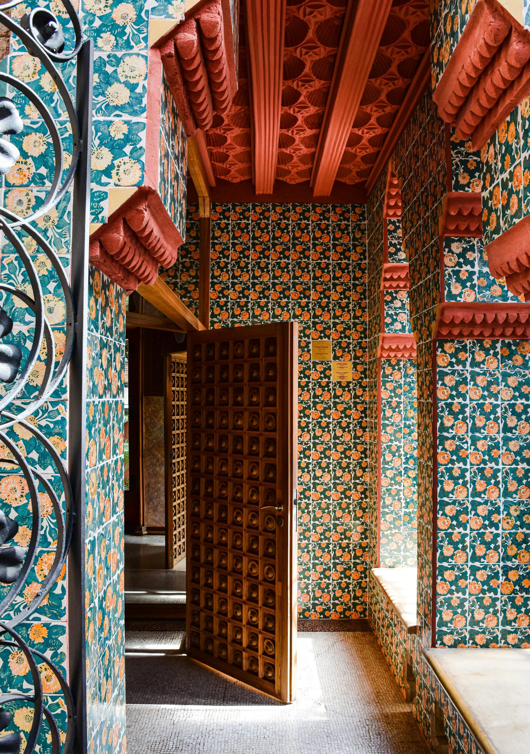 Interior of Casa Vicens in Barcelona featuring vibrant mosaic tile designs and wooden doors.