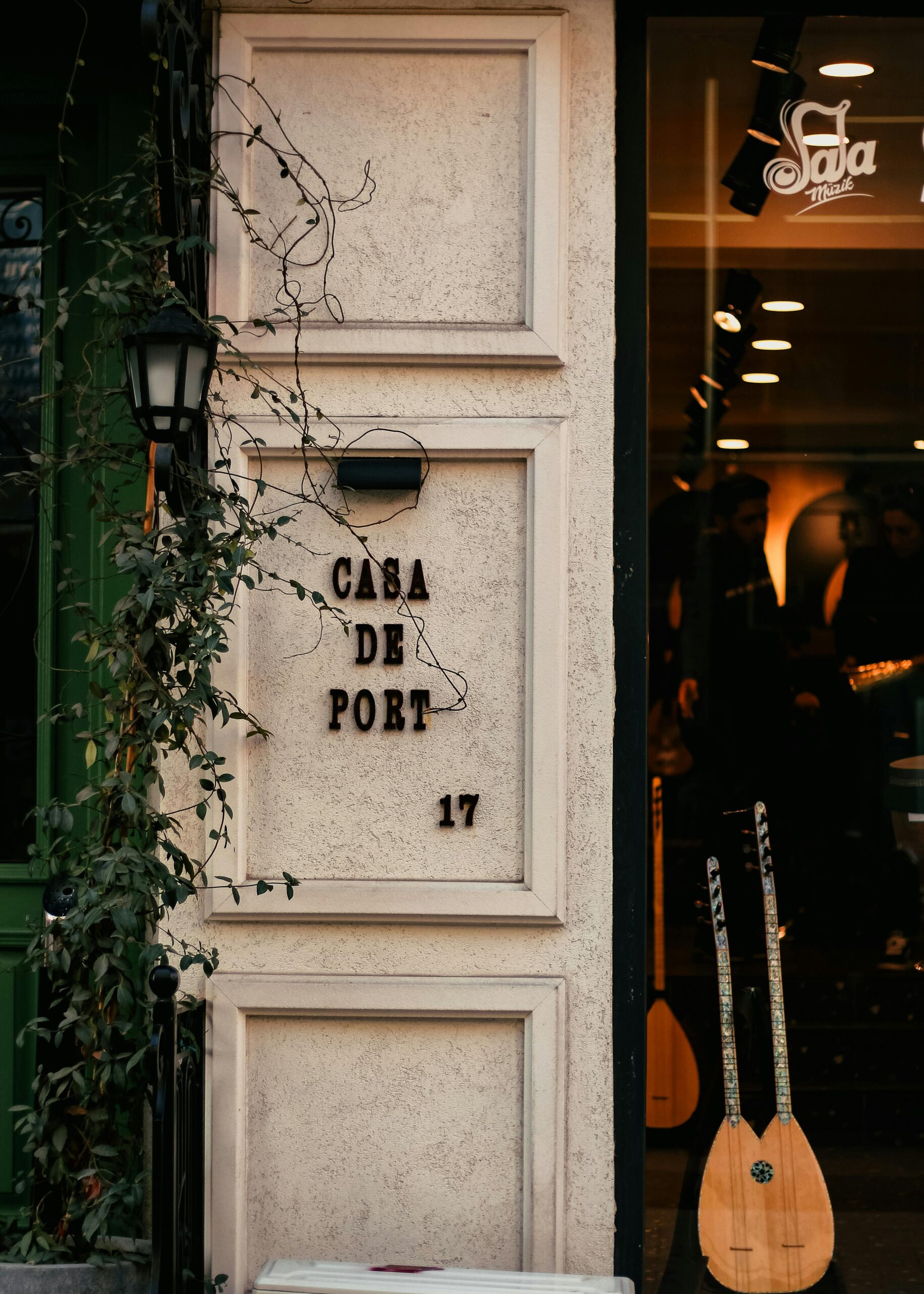 Charming café entrance with vines and guitars on display, offering a warm urban ambiance.